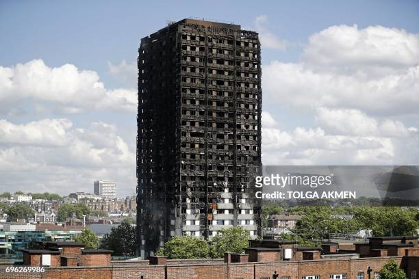 The remains of residential tower block Grenfell Tower are pictured, in west London on June 15 a day after it was gutted by fire. - Firefighters...