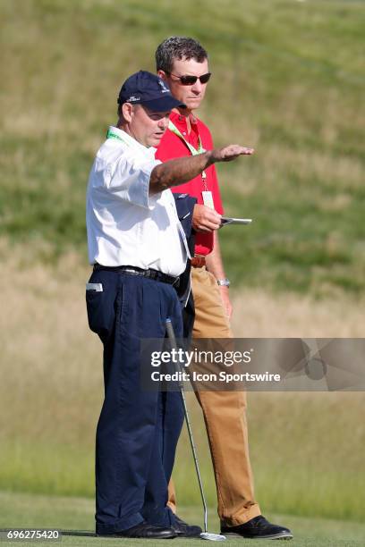 Mike Davis the Executive Director of the USGA sets up the hole locations on the 18th green during a practice round for the 117th US Open at Erin...