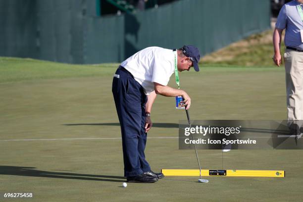 Mike Davis the Executive Director of the USGA sets up the hole locations on the 18th green during a practice round for the 117th US Open at Erin...