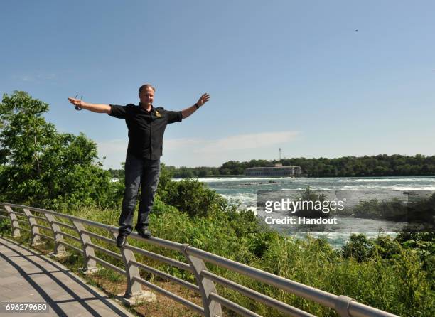 In this handout photo provided by Wallenda Incorporated, Nik Wallenda walks on the railing at Niagara Falls June 14, 2017 in Niagara Falls, New York....
