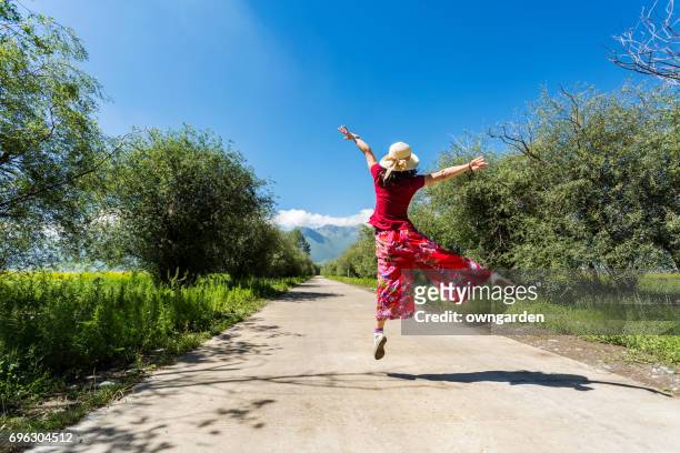women jumping on the road - leap forward stock pictures, royalty-free photos & images
