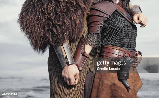 dark haired viking woman and bald viking man in the sea at dusk - chain mail stock pictures, royalty-free photos & images