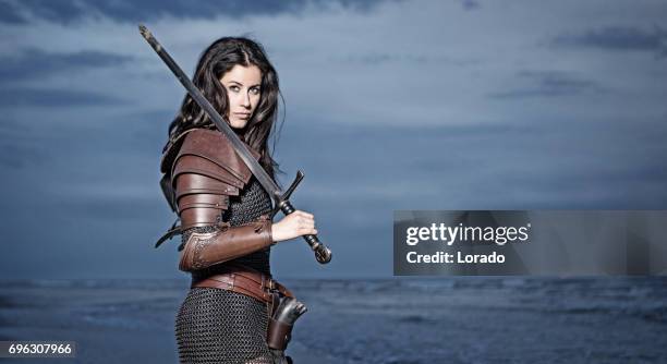 dark haired viking woman in the sea at dusk - traditional armor stock pictures, royalty-free photos & images