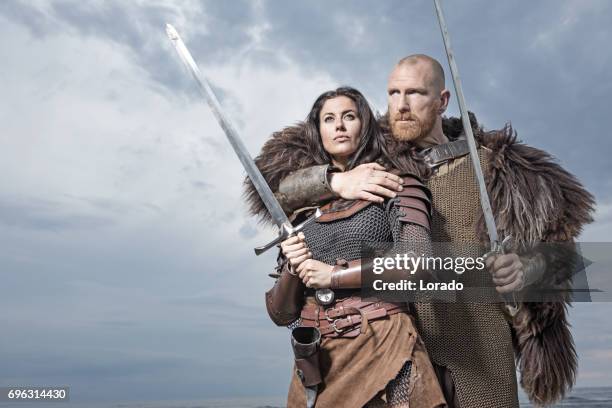 dark haired viking woman and bald viking man together in the sand - cosplay stock pictures, royalty-free photos & images