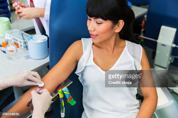 drawing blood...nurse prepairing for blood capture from a vein for laboratory analyses from cute young woman - iv drip womans hand stock pictures, royalty-free photos & images