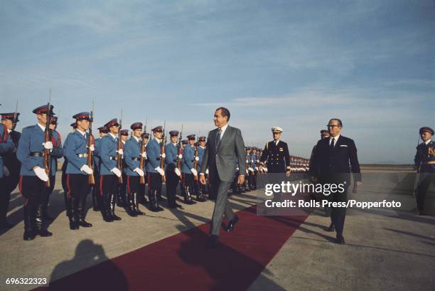 President of the United States, Richard Nixon walks along a red carpet with Josip Broz Tito President of Yugoslavia as they inspect the honour guard...