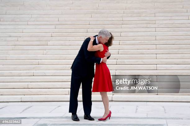 Justice Neil Gorsuch is hugged by his wife Marie Louise Gorsuch on the steps of the US Supreme Court in Washington, DC, June 15, 2017. / AFP PHOTO /...