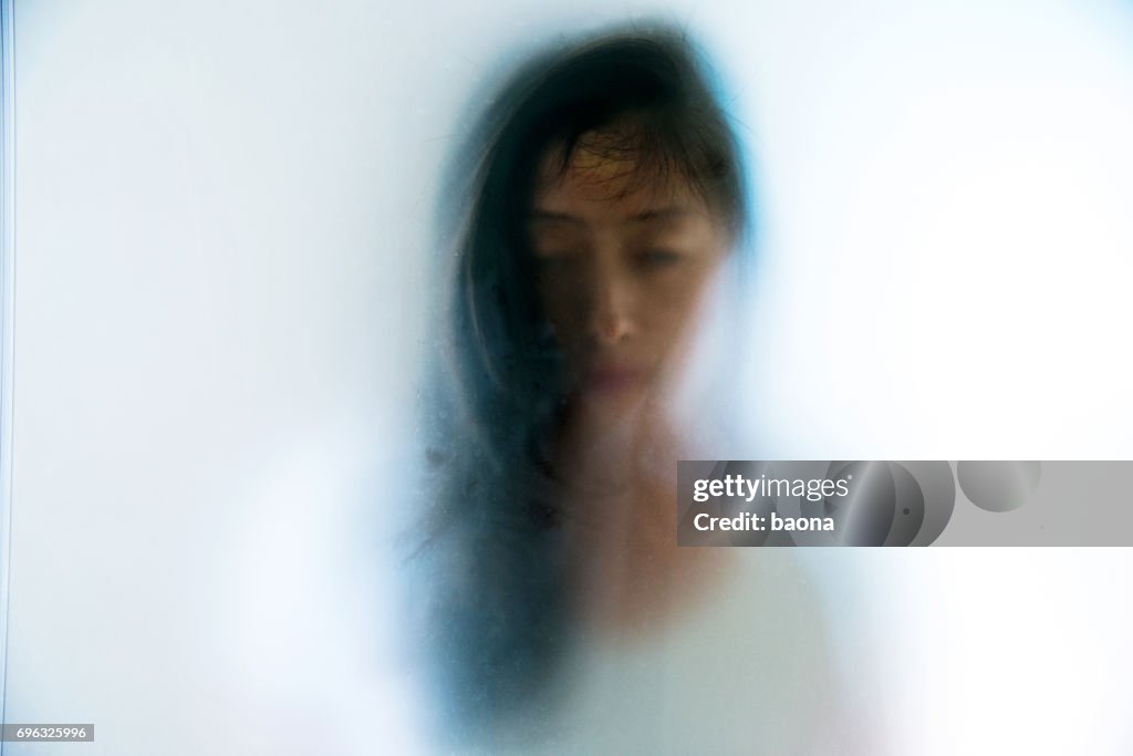 Gezicht van de vrouw "peering" door matglas