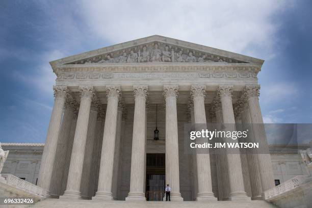 Police officer stands guard on the steps of the US Supreme Court in Washington, DC, June 15, 2017. / AFP PHOTO / JIM WATSON