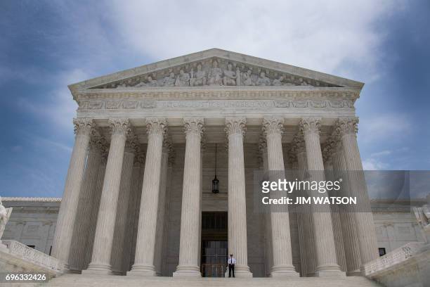 Police officer stands guard on the steps of the US Supreme Court in Washington, DC, June 15, 2017.