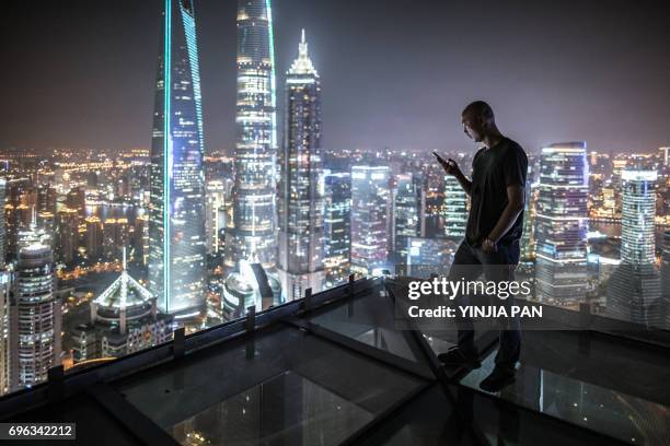 portrait of young man watching smart phone on the roof - rooftop at night bildbanksfoton och bilder