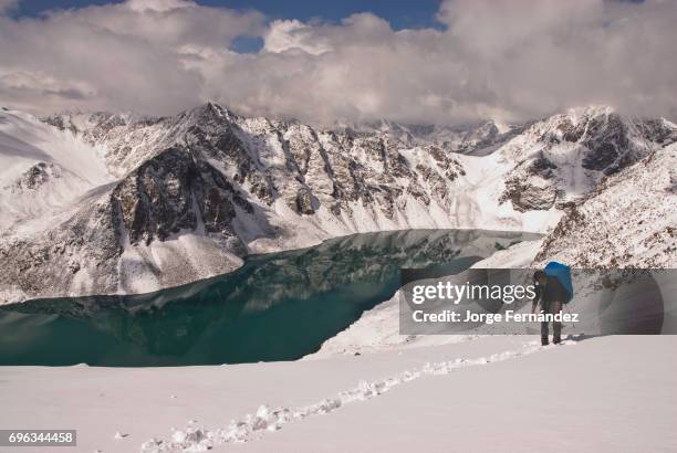 Man trekking on the snow nearby the Ala Kol lake in the Terskey Alatau mountain range.