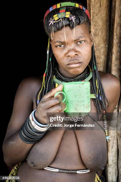 Zemba woman drinking from a plastic cup. Zembas are a bantu tribe family of the Himbas who migrated into what today is Namibia a few centuries ago....
