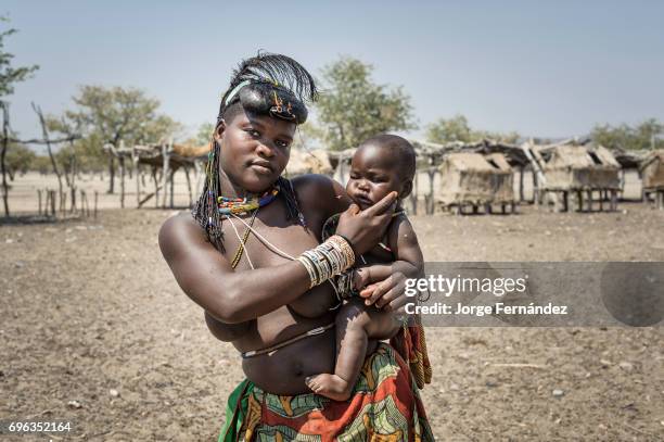 Portrait of a zemba woman with her child. Zembas are a bantu tribe family of the Himbas who migrated into what today is Namibia a few centuries ago....