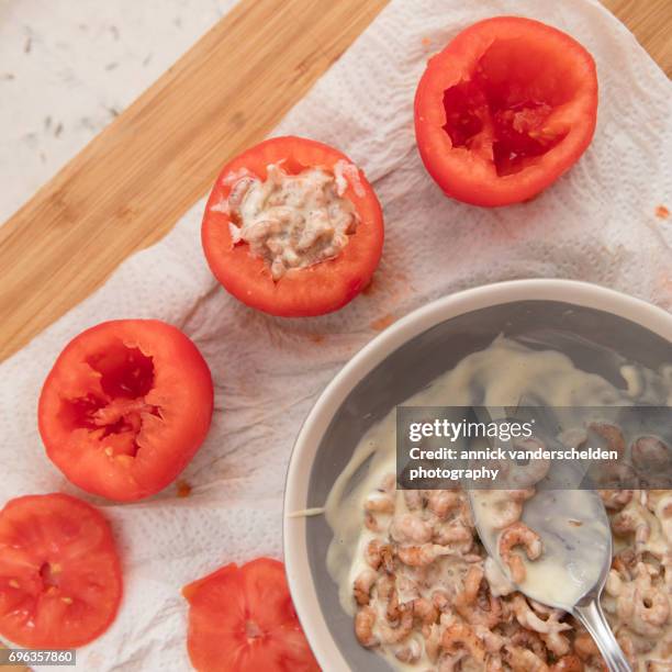 filling hollowed-out tomatoes with shrimp mixture. - white vinegar stock pictures, royalty-free photos & images