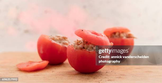 filling hollowed-out tomatoes with shrimp mixture. - hollow stock pictures, royalty-free photos & images