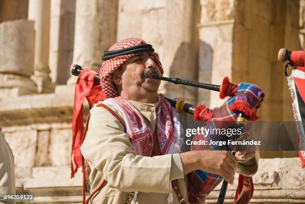 Man playing a bagpipe at the Roman ancient ruins of Jerash.