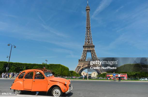 View of an original Citroen 2CV parked in front of Eiffel Tower in Paris. On Thursday, June 15 in Paris, France.