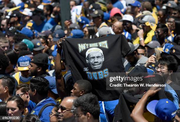 Golden State Warriors fans holding up a t-shirt with LeBron James of the Cleveland Cavaliers picture on that reads "cry baby" and "Don't Mess With...