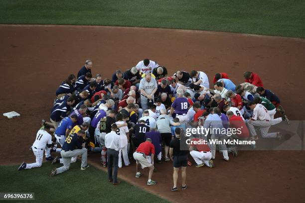 Members of the Republican and Democratic congressional baseball teams gather for a bipartisan prayer before the start of the Congressional Baseball...