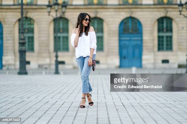 Sarah Benziane, fashion blogger, wears a New Look white lace off shoulder top, New Look blue denim jeans, Zara shoes, and a New Look with embroidered...