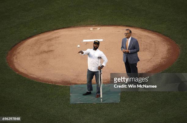Capitol Hill special agent David Bailey , who was wounded in yesterday's shooting, throws out the first pitch before the Congressional Baseball Game...