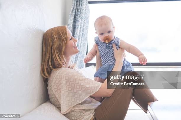 jonge moeder bezit en glimlacht met haar babymeisje - fat women in bath stockfoto's en -beelden