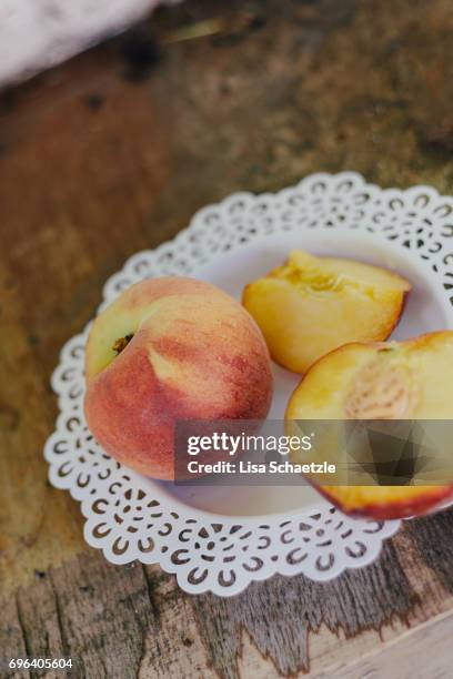 fresh peaches on a plate - speisen und getränke stockfoto's en -beelden