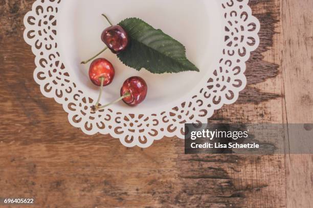 fresh cherries on a plate - konzepte foto e immagini stock