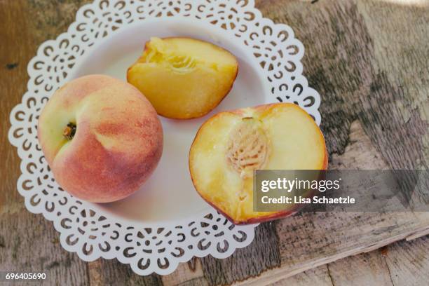 fresh peaches on a plate - speisen und getränke stockfoto's en -beelden