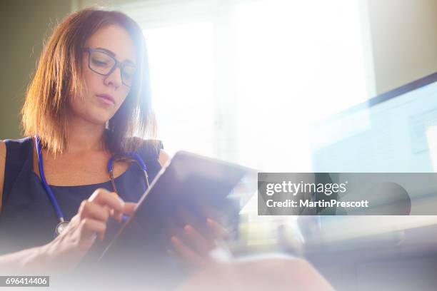 reading patient report on digital tablet - operations manager stock pictures, royalty-free photos & images