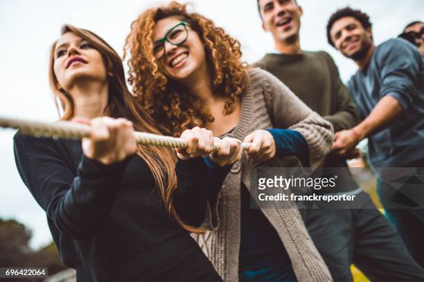 friends enjoy the tug of war game - to pull together stock pictures, royalty-free photos & images