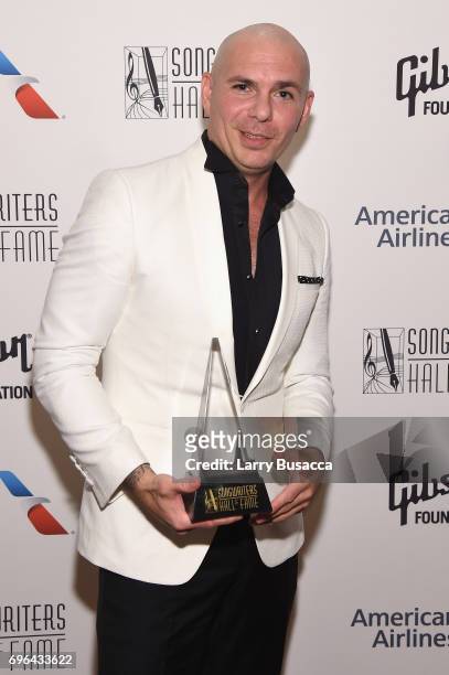 Global Ambassador Award winner Pitbull poses backstage at the Songwriters Hall Of Fame 48th Annual Induction and Awards at New York Marriott Marquis...
