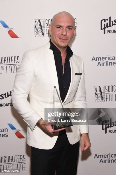 Global Ambassador Award winner Pitbull poses backstage at the Songwriters Hall Of Fame 48th Annual Induction and Awards at New York Marriott Marquis...