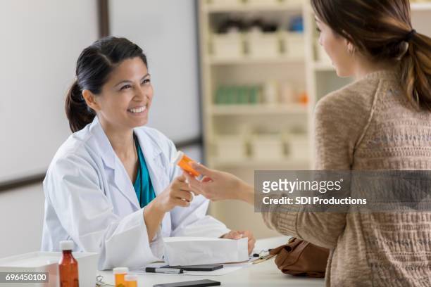young pharmacy customer asks pharmacist questions about medication - pharmacist and patient stock pictures, royalty-free photos & images