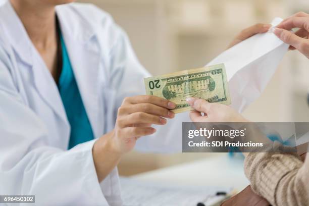 pharmacy customers pays for purchase at checkout counter - american twenty dollar bill stock pictures, royalty-free photos & images