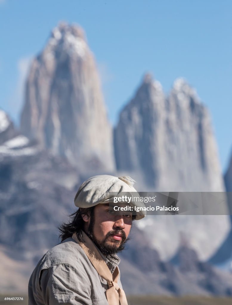 Gaucho (traditional migratory horseman) with Torres del Paine in the background, Torres del Paine National Park