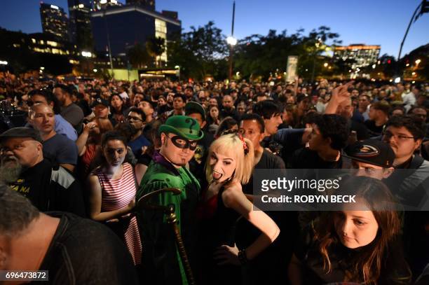 Fans dressed as The Joker and Harley Quinn wait to see the Batman "Bat-signal" projected onto Los Angeles City Hall in a tribute to the late actor...