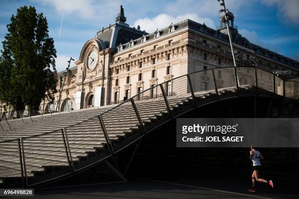 Jogger runs near of the Orsay museum in Paris on June 16, 2017. / AFP PHOTO / JOEL SAGET