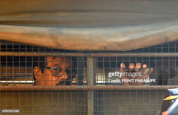 Mustafa Dossa, convicted for his role in the 1993 Mumbai bomb blasts, sits inside a police van as he leaves from Arthur Road Jail for a special court...