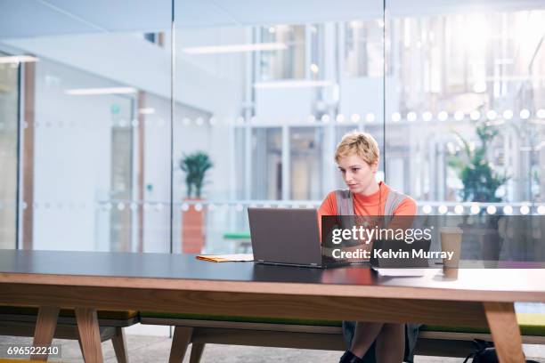 creative businesswoman using laptop in conference room - schreibtisch laptop tablet stock-fotos und bilder