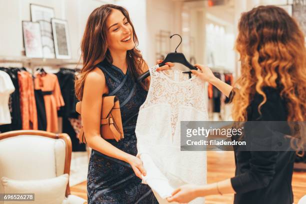 saleswoman suggesting dress to a customer - clothes shop stock pictures, royalty-free photos & images
