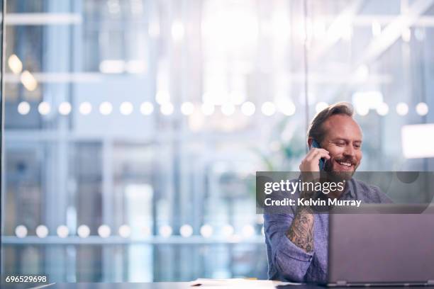 creative businessman using cell phone in office - the global goals 2017 stock-fotos und bilder