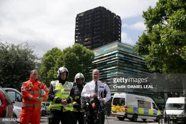 London Police Commander Stuart Cundy makes a statement to the media against the backdrop of the remains of Grenfell Tower, a residential tower block...