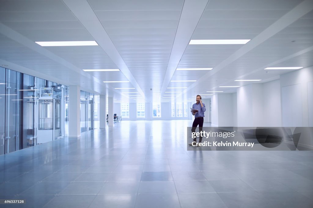 Architect using cell phone in empty office