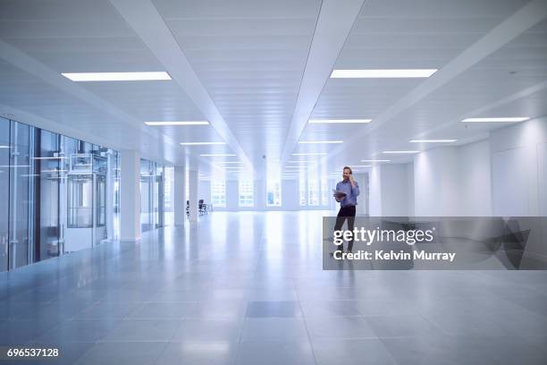 architect using cell phone in empty office - vanishing point technology stock pictures, royalty-free photos & images