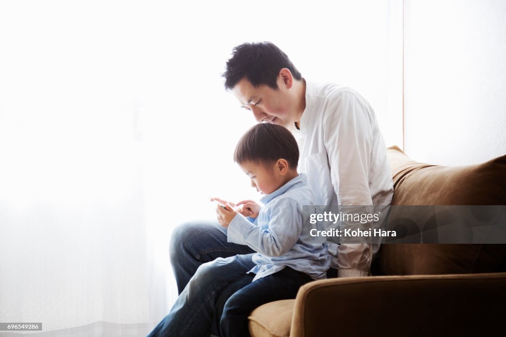 Father and son watching a smart phone together