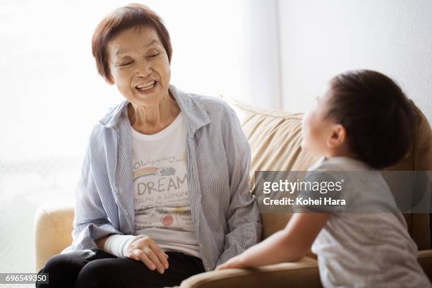 senior woman and her grand son playing at home together - 日本人　英語 ストックフォトと画像