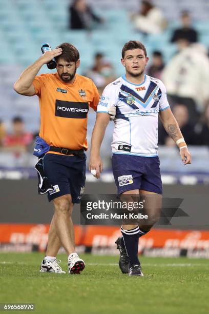 Ashley Taylor of the Titans leaves the field with a trainer after receiving a head knock during the round 15 NRL match between the South Sydney...