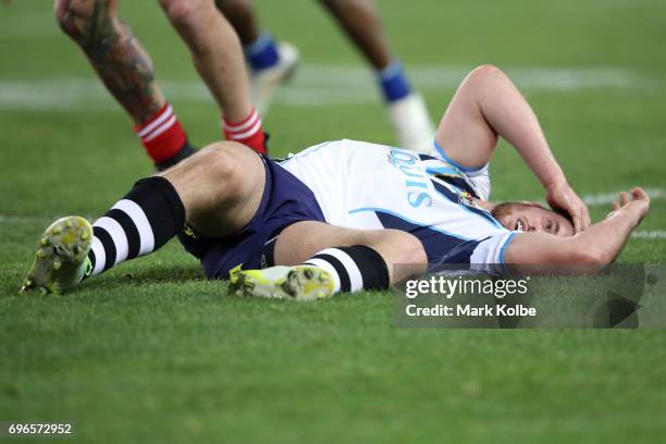 Joe Greenwood of the Titans lies injured on the ground after receiving a head knock during the round 15 NRL match between the South Sydney Rabbitohs...